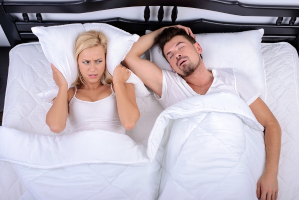 man suffering from sleep apnea keeps bed partner awake