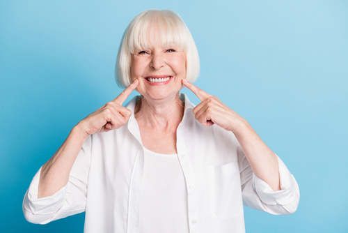 granny blonde hair pointing at white teeth healthy smile 