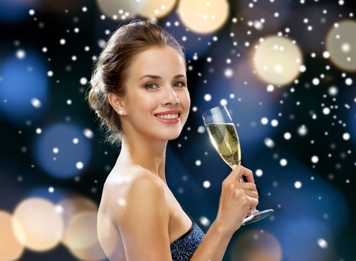 smiling woman in evening dress with glass of sparkling wine